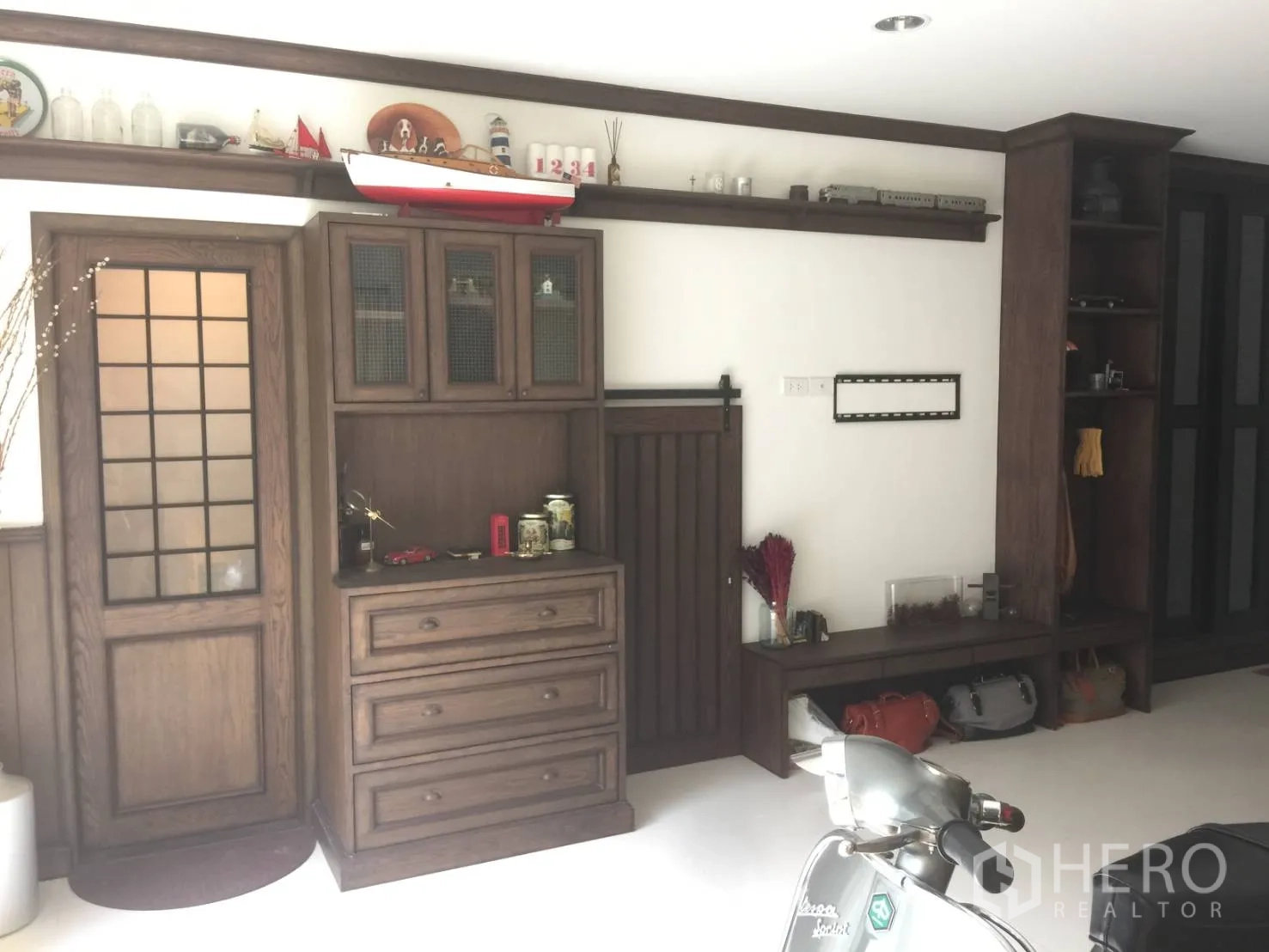 Townhouse for sale in Suan Luang, Bangkok - Entry level or garage with vintage-style wood cabinetry, shelves, and storage bench.