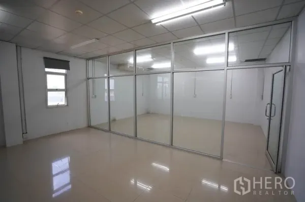 Factory for sale in Khlong Luang, Pathum Thani - Glass-partitioned office area with aluminum frames and glossy tiles.