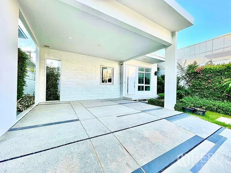 Detached House for rent in Prawet, Bangkok - Covered carport and front porch with tiled floor beside a small landscaped garden.