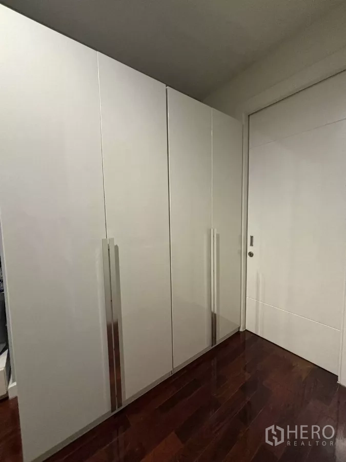 独立式住宅 出租在Bang Kapi, Bangkok - 走廊内的白色衣柜与亮面木地板。