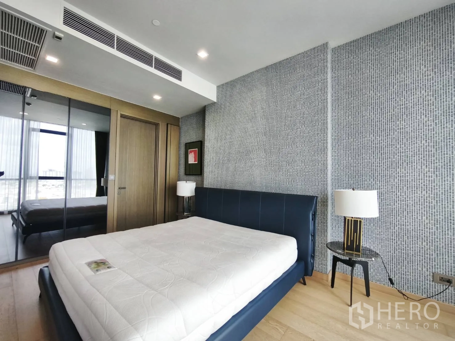 คอนโด for rent in Watthana, Bangkok - ห้องนอนสว่างพร้อมเตียงหุ้มหนัง ตู้เสื้อผ้าบานกระจก และโคมไฟหัวเตียง