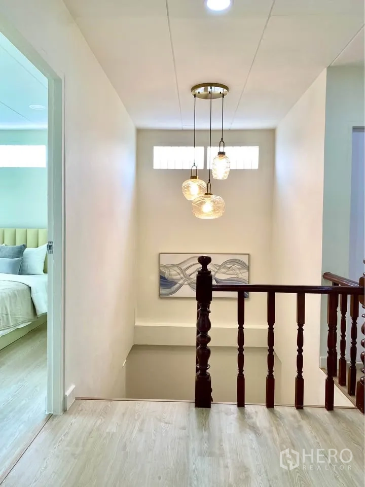 บ้านเดี่ยว for rent in Huai Khwang, Bangkok - โถงบันไดมีโคมไฟแขวน งานศิลปะ และราวบันไดไม้