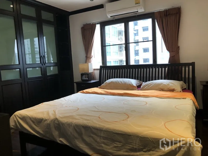 公寓 出租在Watthana, Bangkok - 主卧，落地窗、大型嵌入式衣柜与双人床。