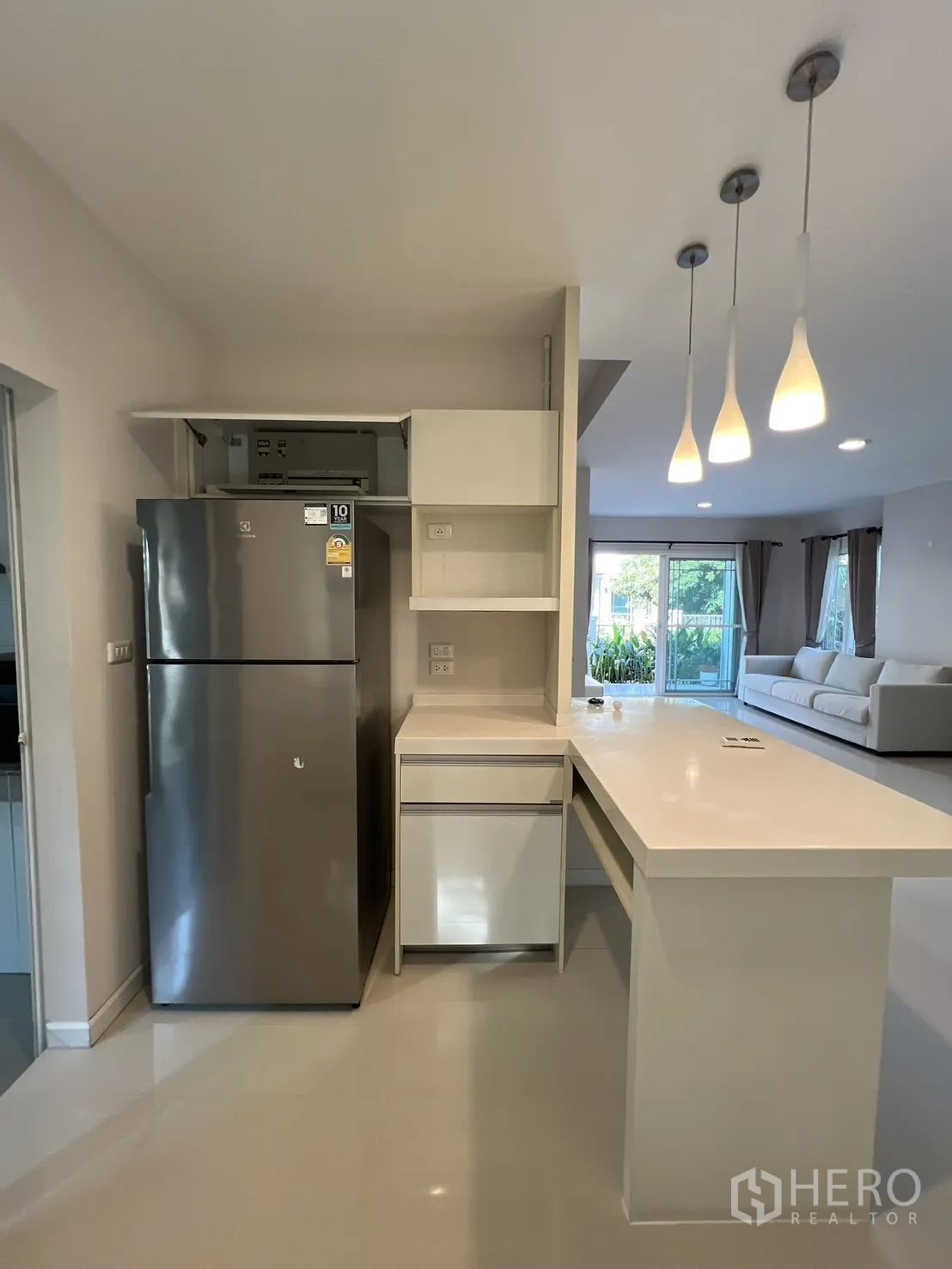 Detached House for rent in Bang Kapi, Bangkok - Kitchenette with long countertop, shelving, and a stainless refrigerator.