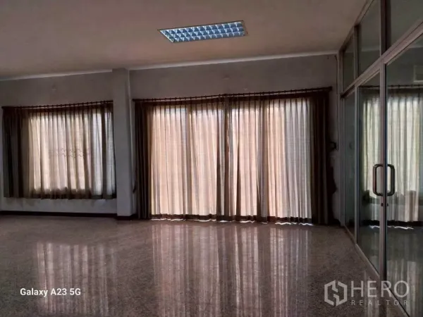 Factory for rent in Phra Samut Chedi, Samut Prakan - Bright office area with large curtained windows, polished floors, and glass partition doors.