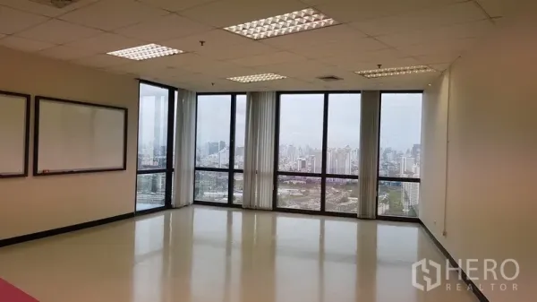 办公空间 出租在Din Daeng, Bangkok - 转角办公室，落地窗配白板，俯瞰曼谷天际线。