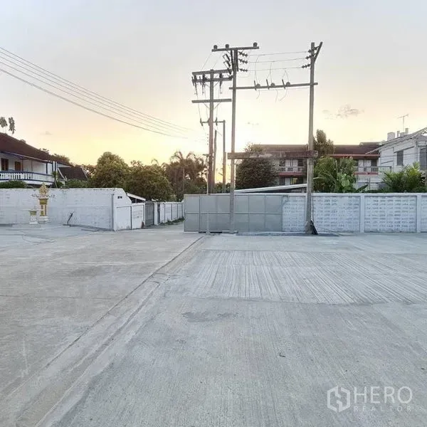 货栈 出租在Prawet, Bangkok - 物业入口与宽阔混凝土空地，配有电线杆