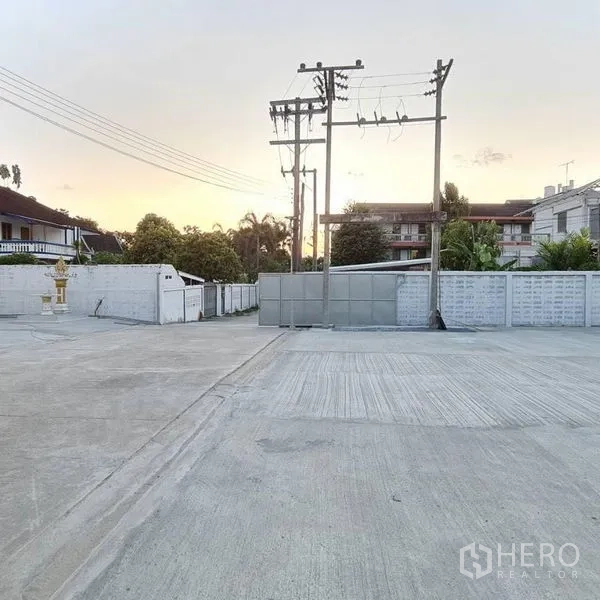 货栈 出租在Prawet, Bangkok - 物业入口与宽阔混凝土空地，配有电线杆