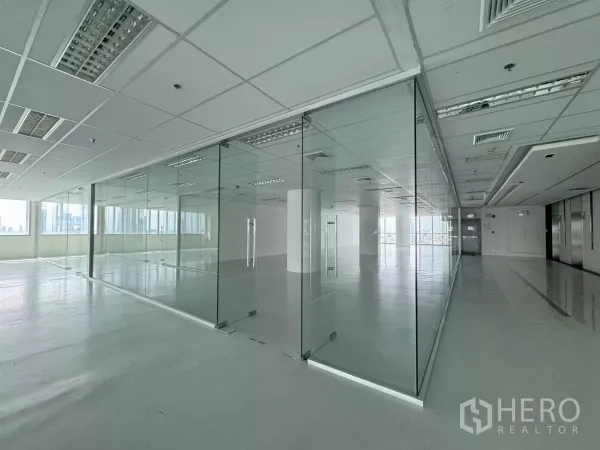 办公空间 出租在Sathon, Bangkok - 明亮的开放式办公室，玻璃隔断会议室与网格吊顶照明，窗外可见城市景观，邻近BTS圣路易站，位于曼谷沙吞。