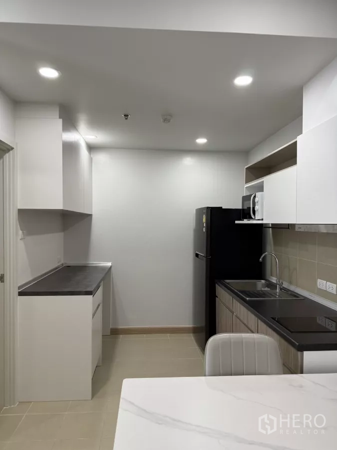 公寓 出租在Khlong Toei, Bangkok - 走廊式厨房，额外操作台与筒灯照明。