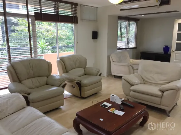 บ้าน ให้เช่าในWatthana, Bangkok - ห้องนั่งเล่นชั้นบน โซฟาหนังสีครีม พื้นไม้ และหน้าต่างบานกว้าง