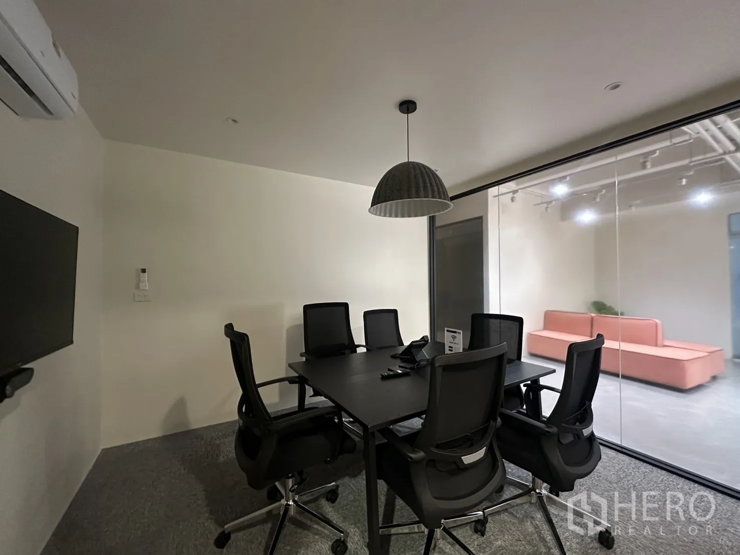 Office Space for rent in Bang Rak, Bangkok - Enclosed conference room with TV, pendant light, and a glass wall facing the corridor.