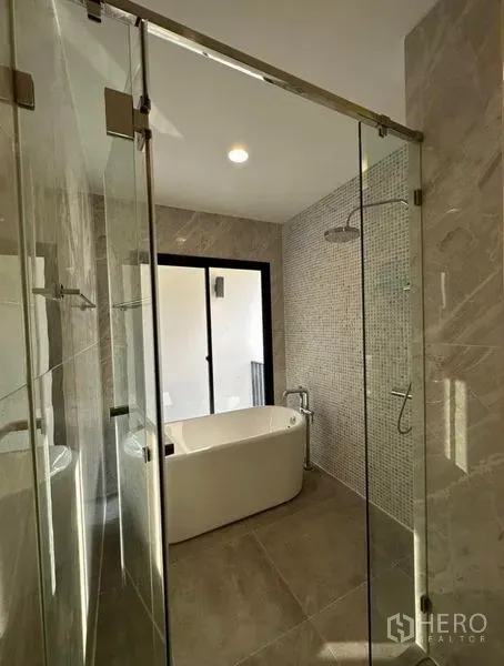Townhouse for rent in Yan Nawa, Bangkok - Modern bathroom featuring a freestanding bathtub, rain shower and glass enclosure.