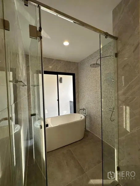 Townhouse for rent in Yan Nawa, Bangkok - Modern bathroom featuring a freestanding bathtub, rain shower and glass enclosure.