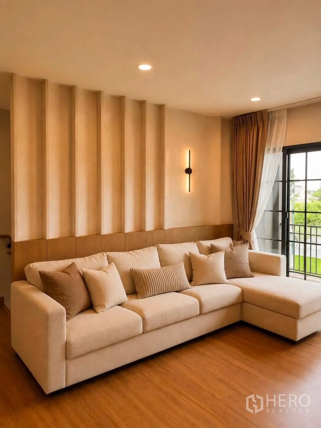 Detached House for rent in Bang Phli, Samut Prakan - Warm living room with an L-shaped beige sofa, wood feature wall and sliding doors.
