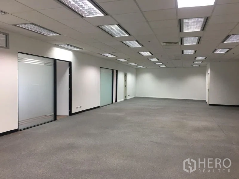 Office Space for rent in Chatuchak, Bangkok - Open-plan office with suspended ceiling lights, white walls, and multiple glass doors.