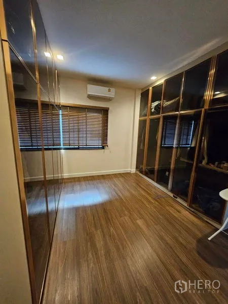 独立式住宅 出售在Mueang Pathum Thani, Pathum Thani - 步入式衣帽间，整面玻璃衣柜与空调。