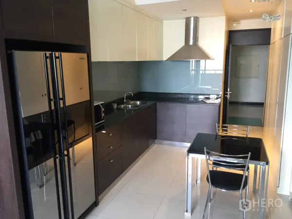 Condominium for rent in Bang Rak, Bangkok - Modern kitchen with stone countertop, stainless hood, double-door fridge and a two-seat dining table.