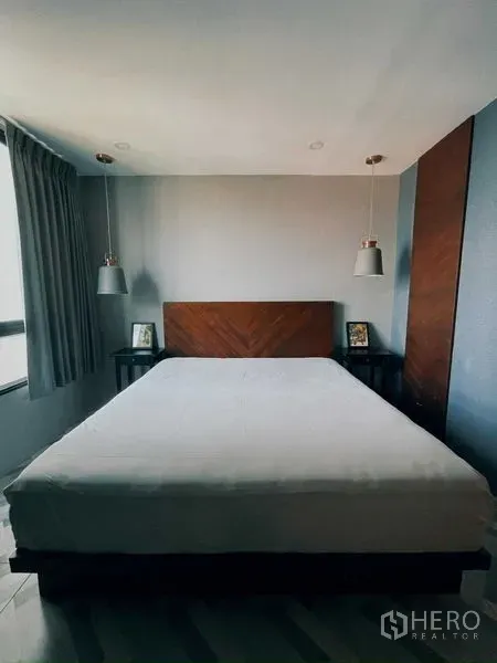 Condominium for rent in Suan Luang, Bangkok - Master bedroom with king bed, wood headboard, and pendant lights