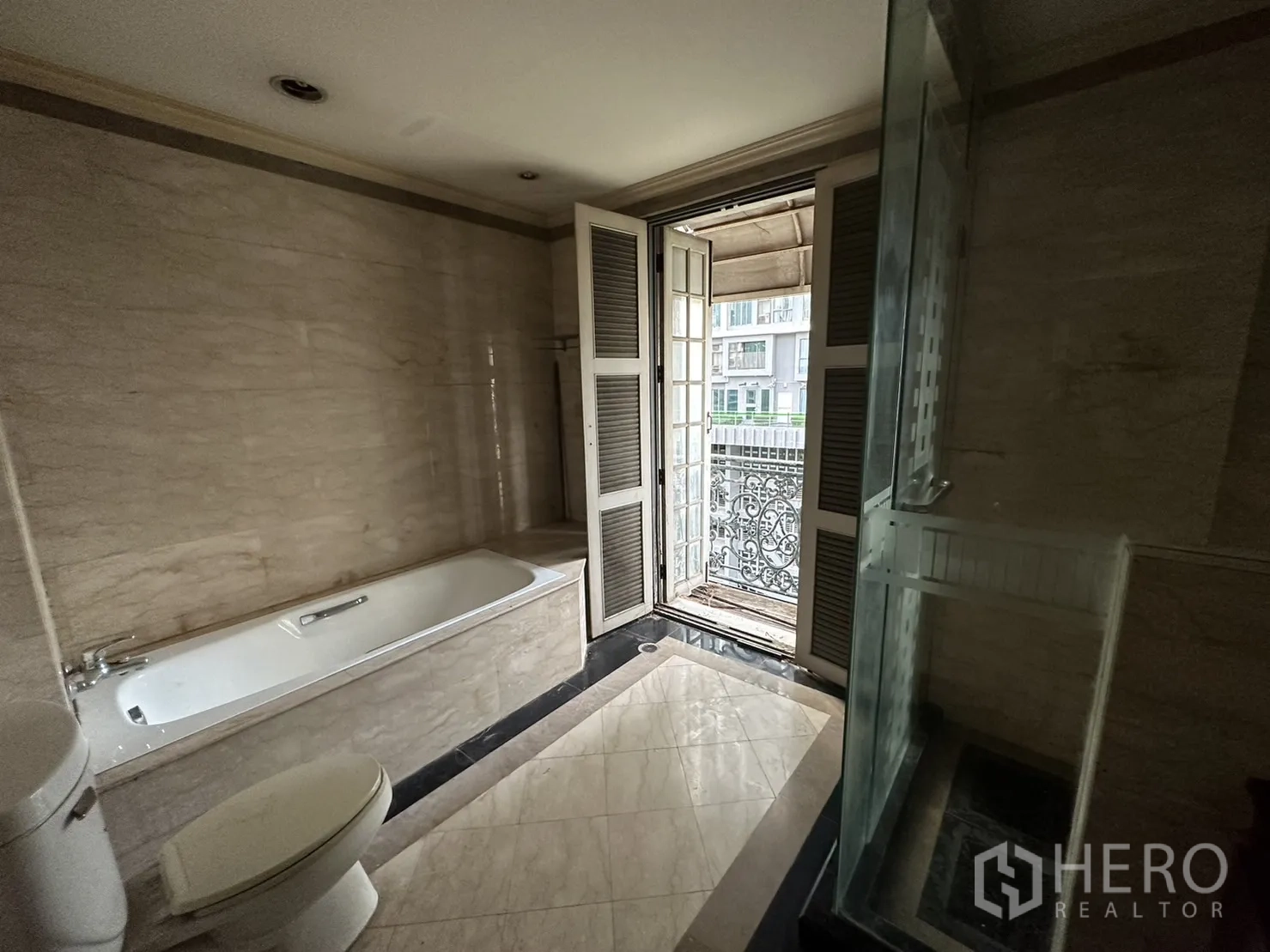 带办公室的家 出租在Huai Khwang, Bangkok - 浴室通向带锻铁栏杆的阳台，旁有浴缸与淋浴。