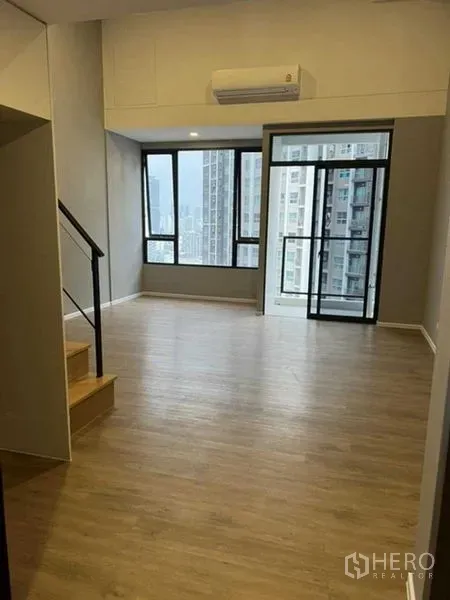 Condominium for sale in Huai Khwang, Bangkok - Bright living space with balcony, air conditioning and urban views.