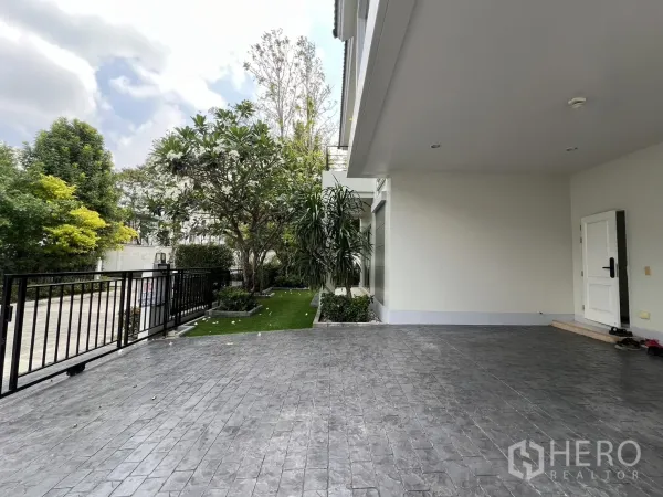 Detached House for rent in Saphan Sung, Bangkok - Covered parking area leading to front gate with side garden and trees.