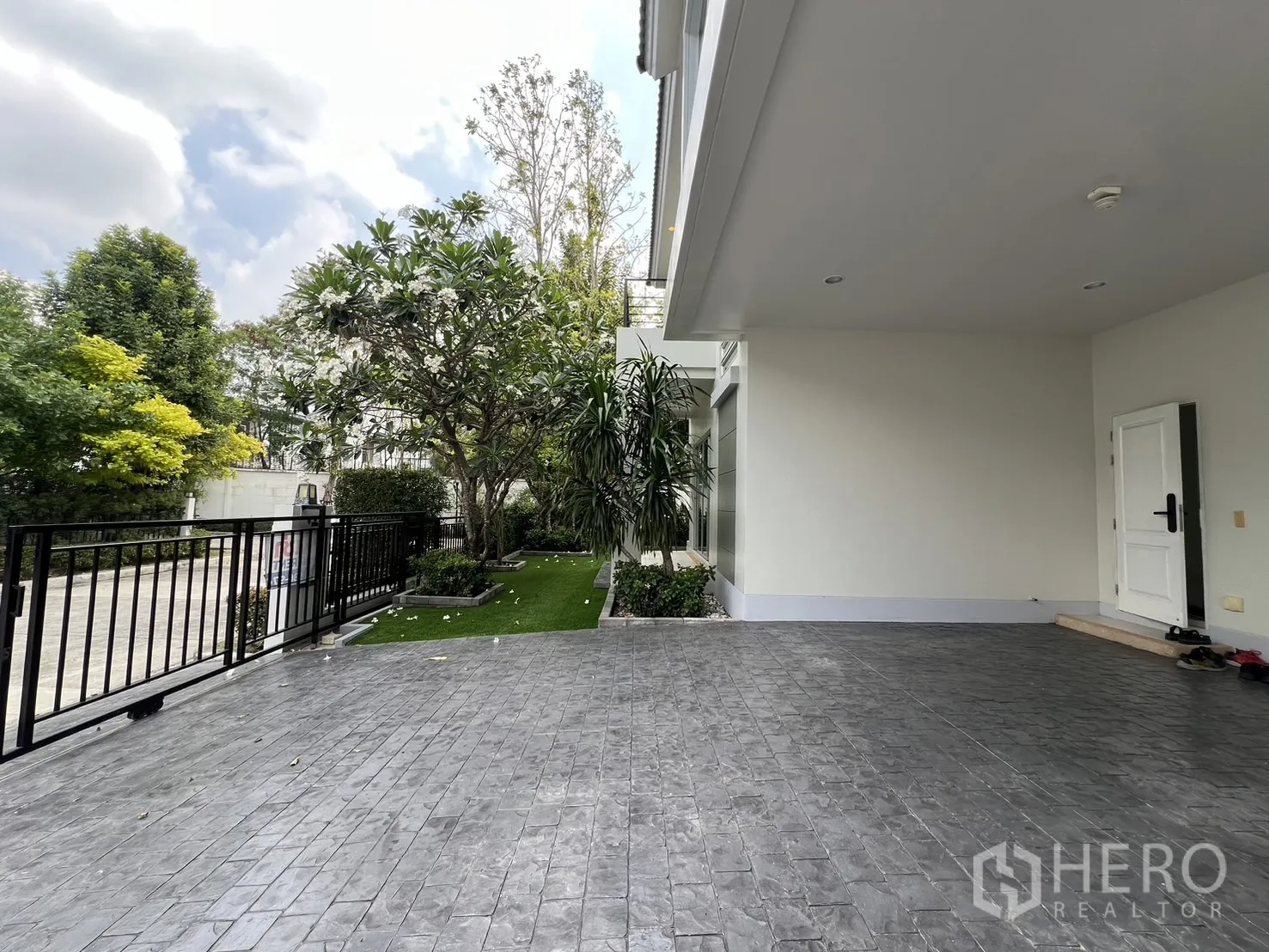 Detached House for rent in Saphan Sung, Bangkok - Covered parking area leading to front gate with side garden and trees.