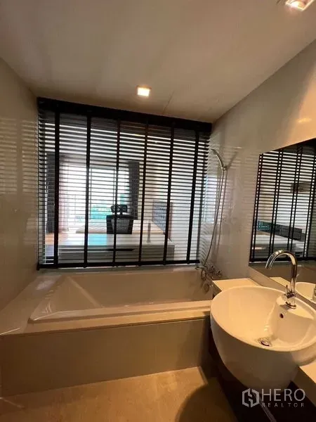 คอนโด ขายในWatthana, Bangkok - ห้องน้ำพร้อมอ่างอาบน้ำ มีหน้าต่างบานเกล็ดมองไปยังห้องนอน