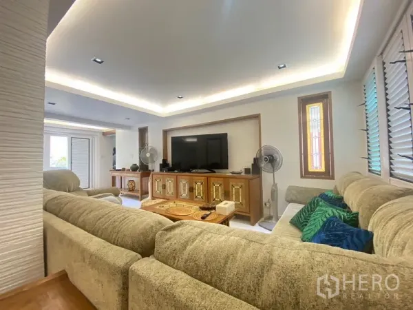 独立式住宅 出售在Khlong Toei, Bangkok - 明亮客厅，L形沙发、电视柜与灯槽顶。