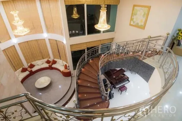 Detached House for rent or sale in Bang Kapi, Bangkok - Double-height foyer with curved wooden staircase, chandeliers and a grand piano.