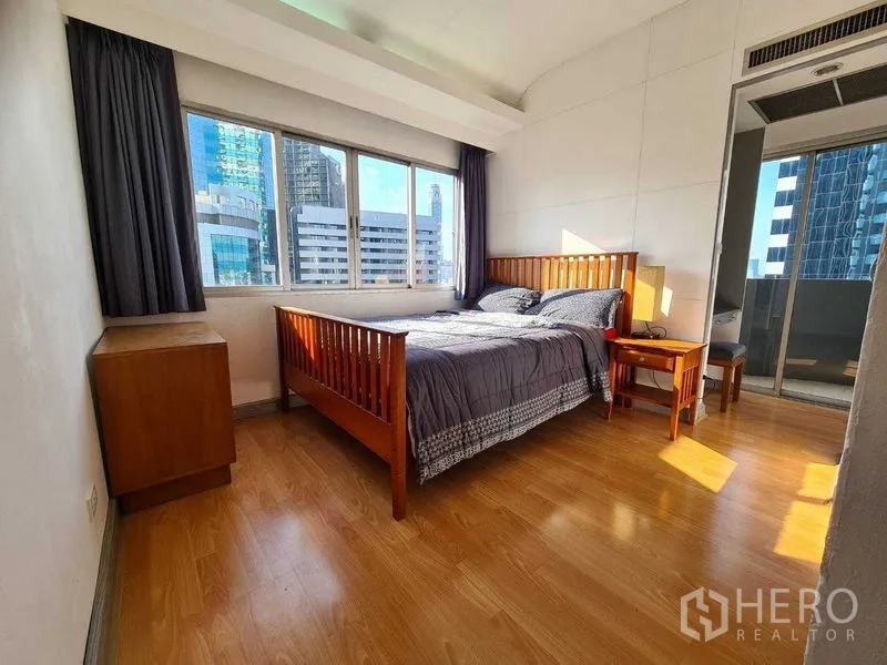 คอนโด ให้เช่าในRatchathewi, Bangkok - ห้องนอนหลักมีหน้าต่างบานใหญ่ เตียงไม้ และทางออกสู่ระเบียง