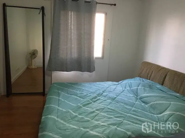 公寓 出租或出售在Yan Nawa, Bangkok - 第二卧室，薄荷绿色床品，落地穿衣镜，带窗帘的窗户与木地板。