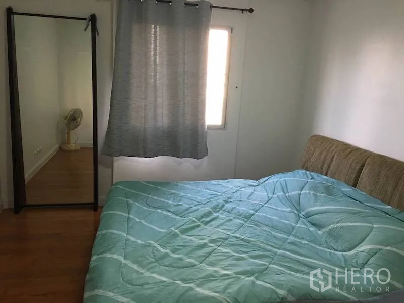 公寓 出租或出售在Yan Nawa, Bangkok - 第二卧室，薄荷绿色床品，落地穿衣镜，带窗帘的窗户与木地板。