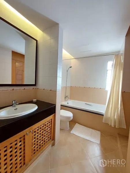 Apartment for rent - Bright bathroom with bathtub, vanity and a window for natural light.