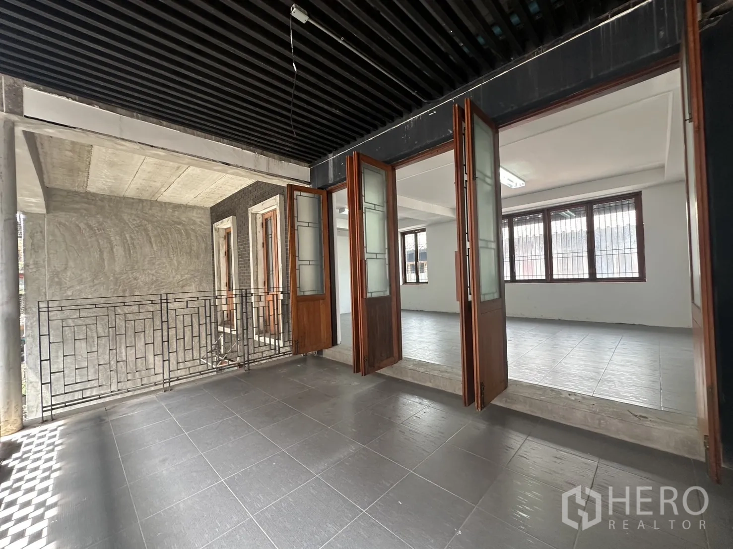 带办公室的家 出租在Pathum Wan, Bangkok - 半室外阳台，黑色格栅天花，台阶连接主室。