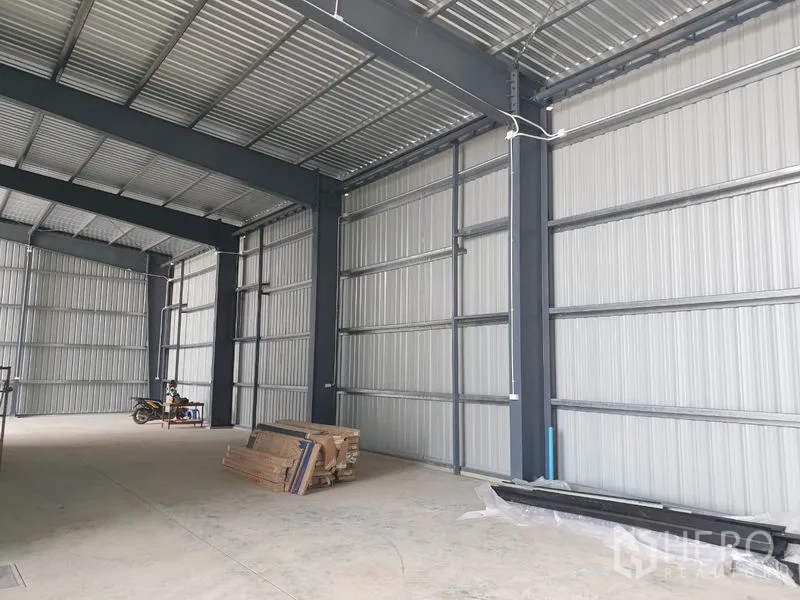 Warehouse for rent in Lam Luk Ka, Pathum Thani - Spacious warehouse interior with high ceiling, steel structure and concrete floor.