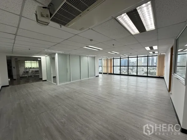 办公空间 出租在Watthana, Bangkok - 明亮办公区，木纹地板、嵌入式照明与玻璃隔断，俯瞰瓦他那区天际线。