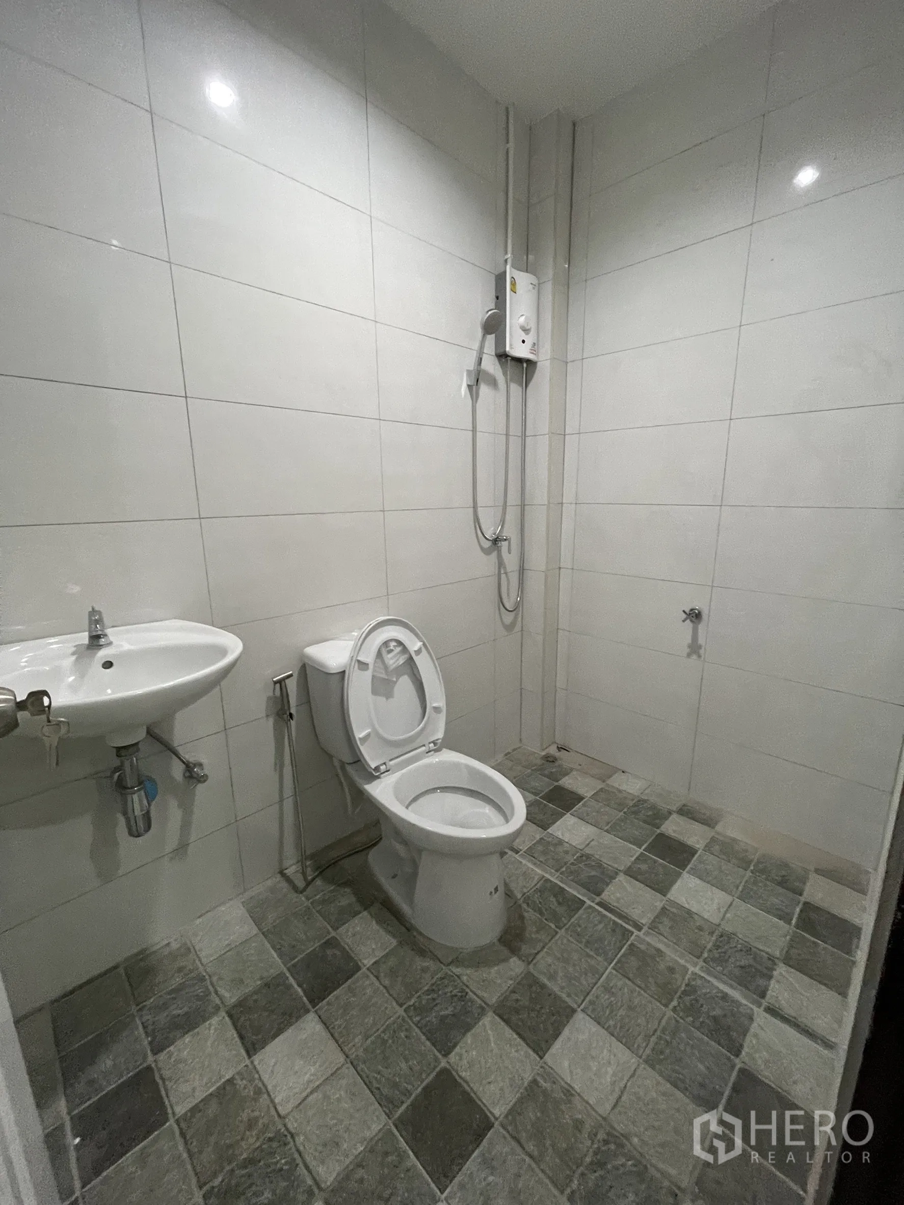 Factory for rent or sale in Lam Luk Ka, Pathum Thani - Restroom with shower, toilet, and checkered floor tiles.