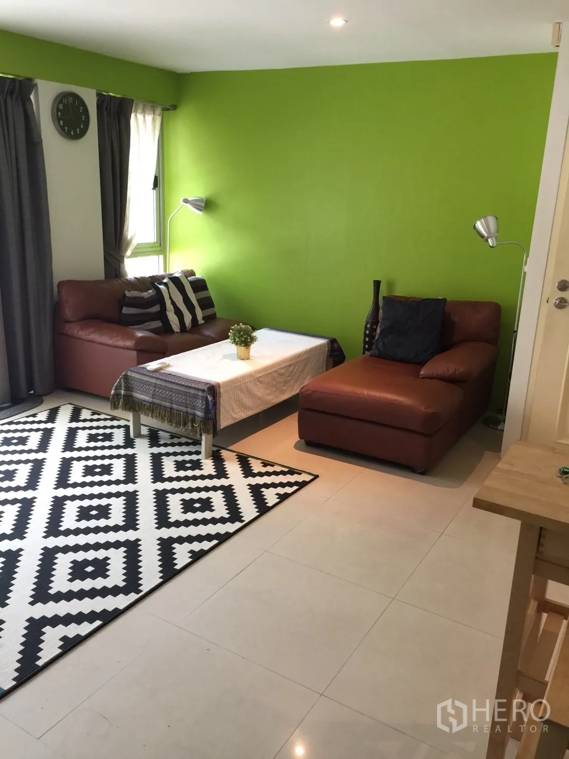 Condominium for rent in Khlong Toei, Bangkok - Living room close-up with black-and-white patterned rug, coffee table, and sofa by the window.