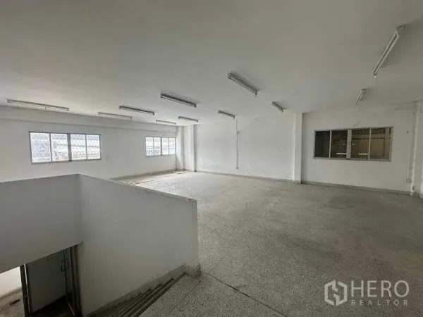 Factory for rent in Nonthaburi - Spacious upper-level office with windows and ceiling lights, ready for fit-out.