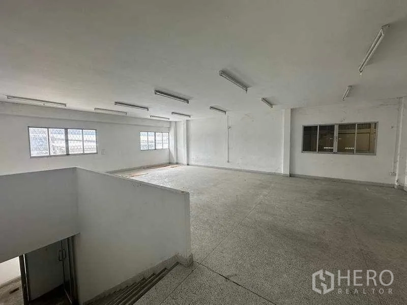 Factory for rent in Nonthaburi - Spacious upper-level office with windows and ceiling lights, ready for fit-out.
