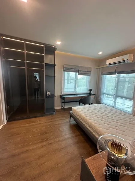 Detached House for rent in Samut Prakan - Bedroom with glass-door wardrobe, writing desk and large windows.