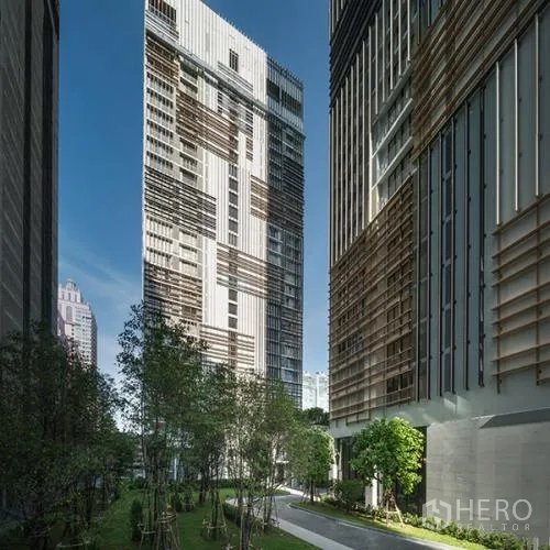 Condominium for rent or sale in Khlong Toei, Bangkok - Exterior of modern high-rise condominium with landscaped garden walkway between towers.