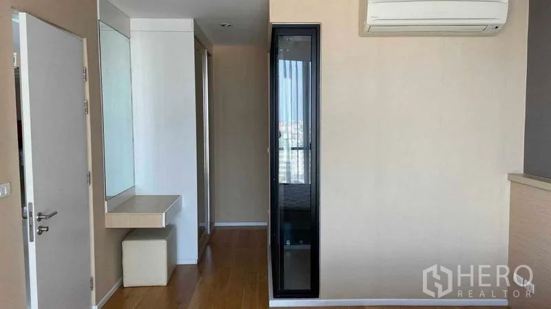 公寓 出租在Watthana, Bangkok - 卧室前厅配梳妆台、衣柜、木地板与壁挂空调。