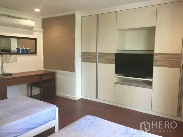 คอนโด ให้เช่าในWatthana, Bangkok - ห้องนอนที่สองมีตู้เสื้อผ้าบิวท์อิน ช่องวางทีวี โต๊ะทำงาน เครื่องปรับอากาศ และพื้นไม้