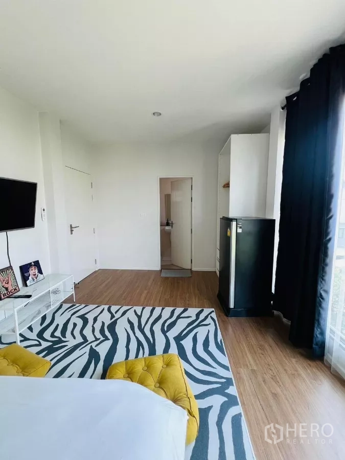 Detached House for rent in Saphan Sung, Bangkok - Bright master bedroom with zebra rug, wall-mounted TV, fridge and ensuite access.