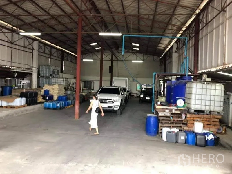คลังสินค้า ขายในLam Luk Ka, Pathum Thani - โซนโกดังหลังคาสูง มีรถกระบะและถังบรรจุ วางของเป็นระเบียบ ทางรถวิ่งผ่านได้ แสงสว่างเพียงพอ