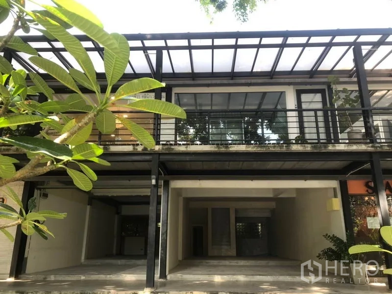 Retail Space for rent in Watthana, Bangkok - Two-storey retail unit with steel canopy, glass frontage and leafy garden at the entrance.