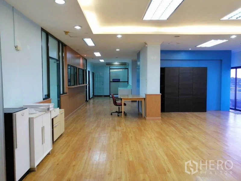 办公空间 出租在Bueng Kum, Bangkok - 开放式工作区，蓝色点缀墙、办公桌与顶灯。
