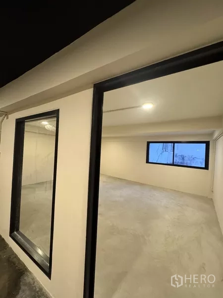 Shophouse for rent - Double‑height hall with mezzanine, black ceiling and stair access for display or events.